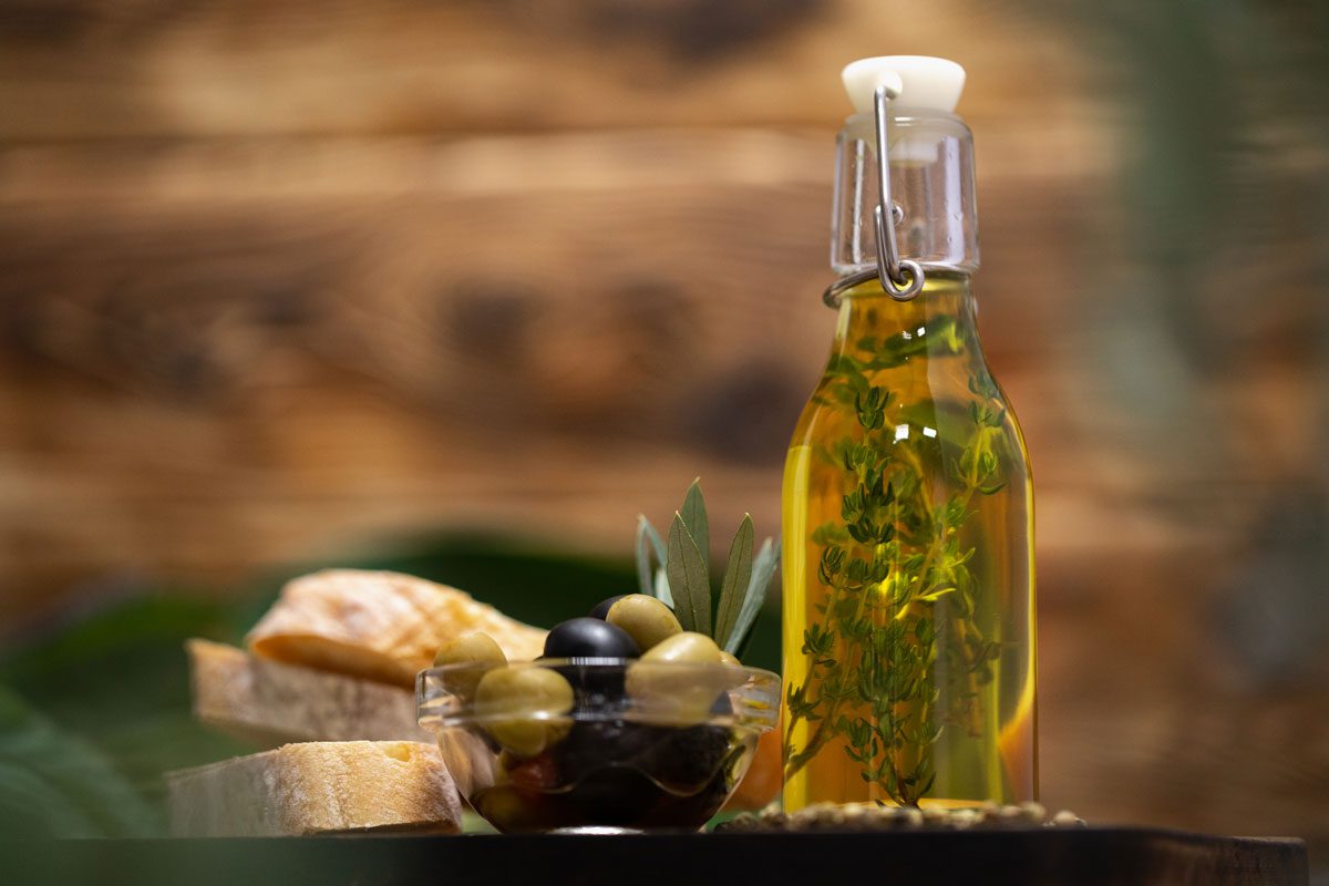 Vorteile von Olivenöl-olives-bottle-olive-oil-wooden-background