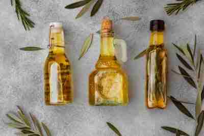 Glasflasche-Mit-Olivem-Öl-Grauem-Hintergrund